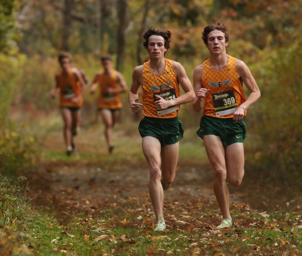 Nate Julien, left, of Firestone and teammate Quinn Hopkins run to a first and second place finish in the City Series Cross Country Meet at Goodyear Heights Metro Park Wednesday in Akron. 