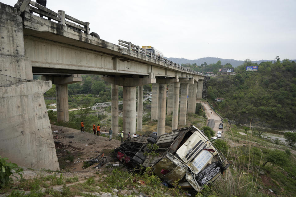 Rescue team inspects the wreckage after a bus carrying Hindu pilgrims to a shrine skid off a highway bridge into a Himalayan gorge near Jammu, India, Tuesday, May 30, 2023. (AP Photo/Channi Anand)