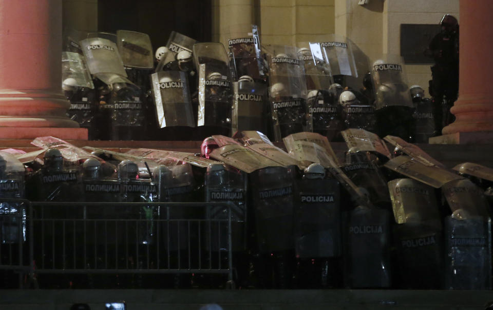 Serbian riot police guard the Serbian parliament building during a protest in Belgrade, Serbia, Friday, July 10 2020. Hundreds of demonstrators tried to storm Serbia's parliament on Friday, clashing with police who fired tear gas during the fourth night of protests against the president's increasingly authoritarian rule. The protests started on Tuesday when President Aleksandar Vucic announced that Belgrade would be placed under a new three-day lockdown following a second wave of confirmed coronavirus infections. (AP Photo/Darko Vojinovic)