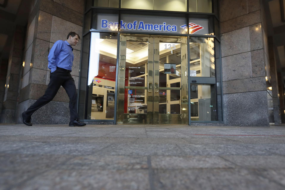 In this Monday, Oct. 14, 2019 photo a passer-by walks past the entrance to a Bank of America ATM, in Boston. Bank of America Corp. reports financial results Wednesday, Oct. 16.(AP Photo/Steven Senne)