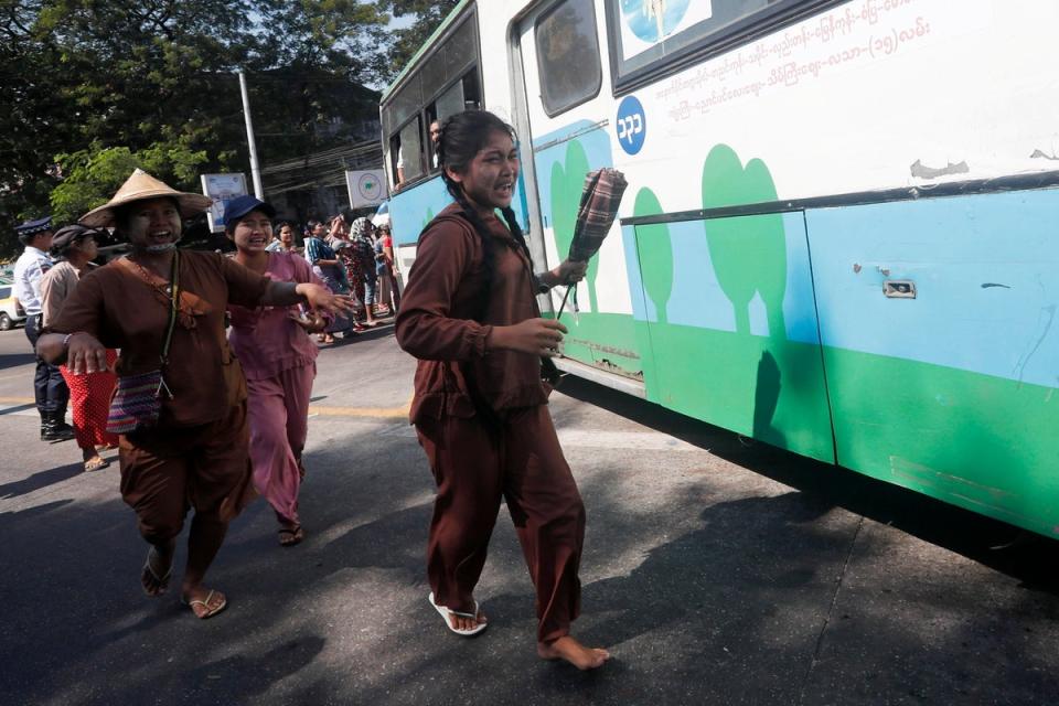 Relatives react as a bus carrying released inmates exits Insein prison in Yangon, Myanmar (EPA)