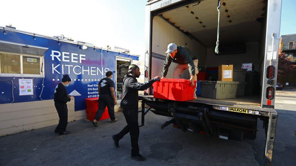 A delivery is received from the production kitchen. A ghost kitchen, by Reef Technology, operates in a small parking lot on A Street in South Boston on November 11, 2021. The chefs create meals for several restaurants. - Pat Greenhouse/The Boston Globe/Getty Images