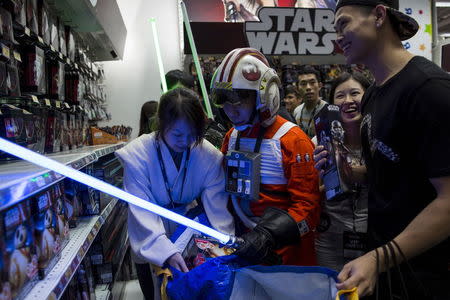 A fan (C) dressed as Luke Skywalker picks new toys from the upcoming film "Star Wars: The Force Awakens" on "Force Friday" after the launch of the film's new toys in Hong Kong, China, September 4, 2015. REUTERS/Tyrone Siu