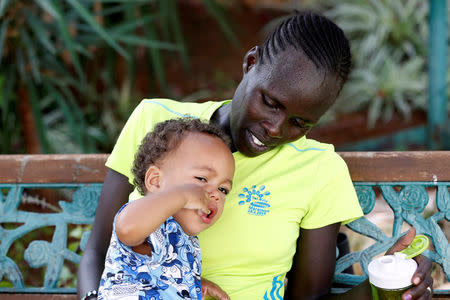 Lonah Chemtai, a Kenyan-born runner who will represent Israel in the women's marathon at the 2016 Rio Olympics, looks at her 19 month-old son, Roy Salpeter, after training with her husband and coach, Israeli Dan Salpeter, near their house in Moshav Yanuv, central Israel July 14, 2016. REUTERS/Baz Ratner