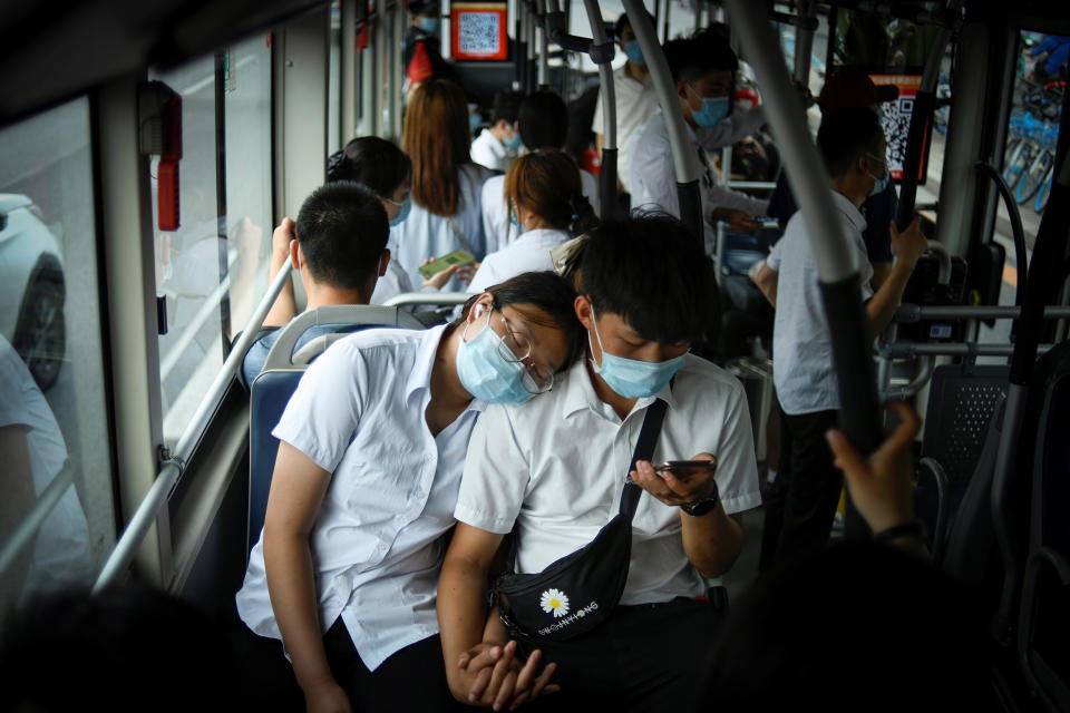 Image: A couple wearing face mask ride on a bus during rush hour in Beijing (Wang Zhao / AFP via Getty Images file)