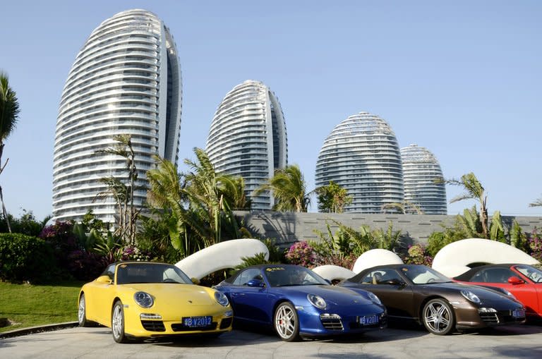 Sports cars parked in front of luxury apartment blocks at Phoenix Island, in the Chinese seaside city of Sanya, on January 19, 2013. Chinese manufacturers once snapped up luxury apartments on Phoenix Island, but with profits falling as a result of the global downturn many owners need to offload properties urgently and raise cash to repay business loans, estate agents said