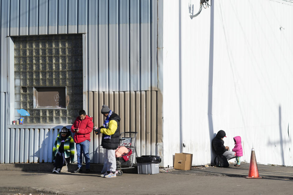 FILE - Immigrants stand outside a shelter in the Pilsen neighborhood of Chicago, Dec. 19, 2023. Officials have confirmed seven cases of measles among shelter residents since Thursday, March 7, 2024, prompting a push to boost vaccinations with support from the Centers for Disease Control and Prevention. (AP Photo/Charles Rex Arbogast, File)