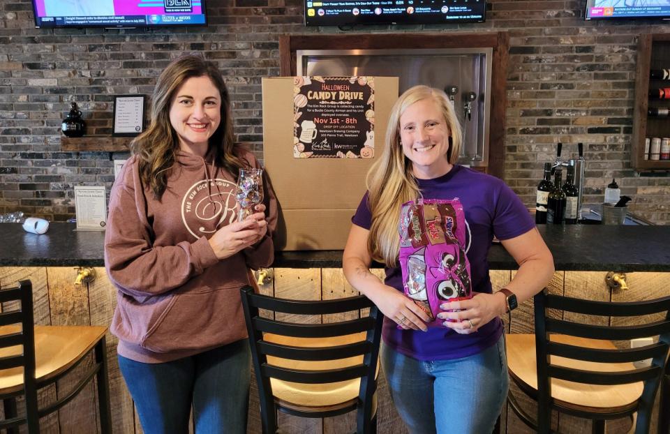 Realtor Kim Rock (left) and Liz Howell of the Kim Rock Group at Keller Williams Real Estate set up a bin at the Newtown Brewing Co. in Newtown Township to collect candy to be sent to the military.