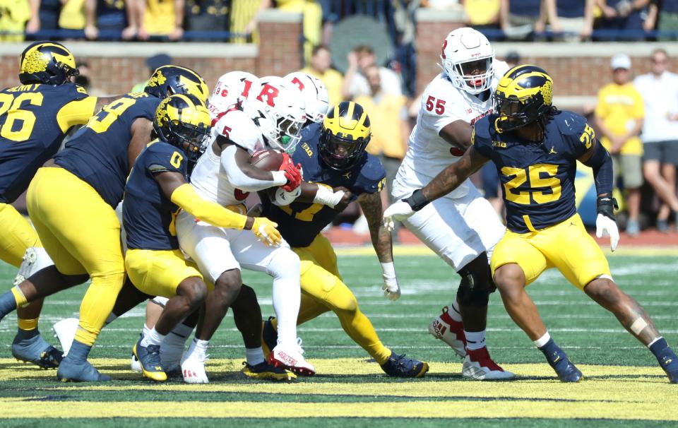 Michigan Wolverines defensive back Mike Sainristil (0) tackles Rutgers Scarlet Knights running back Kyle Monangai (5) during the first half at Michigan Stadium, Saturday, Sept. 23, 2023.