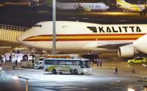 A bus carrying U.S. passengers who were aboard the quarantined cruise ship the Diamond Princess arrives at Haneda airport in Tokyo, before the passengers board a Kalitta airplane chartered by the U.S. government Monday, Feb. 17, 2020. The cruise ship was carrying nearly 3,500 passengers and crew members under quarantine. (Sadayuki Goto/Kyodo News via AP)