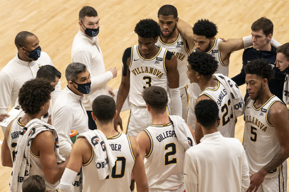 Villanova's head coach Jay Wright, center left, talks things over with his team during the first half of an NCAA college basketball game against Providence, Saturday, Jan. 23, 2021, in Villanova, Pa. (AP Photo/Chris Szagola)