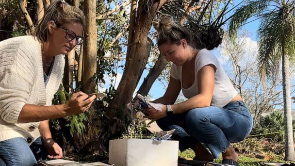 PHOTO: Krista Kowalczyk, owner of Impressions Photography, works with her assistant Maddie Briggs to recover photographs in Fort Myers, Florida, after Hurricane Ian. (Courtesy of Impressions Photography)