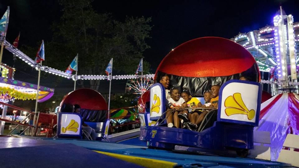 The Brown family screams while riding the Tilt-A-Whirl ride during the Youth Fair opening day on Thursday, March 14, 2024, at the Miami-Dade Fair and Exposition.