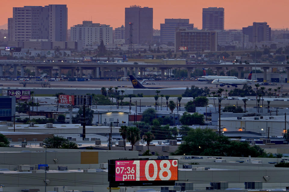 A sign displays the temperature as jets taxi at Sky Harbor International Airport at dusk, Wednesday, July 12, 2023 in Phoenix. Millions of people around the Southwest are living through a historic heat wave. Even the heat-experienced desert city of Phoenix is being tested Wednesday as temperatures hit 110 degrees Fahrenheit for more than a dozen consecutive days. Phoenix is currently America's hottest large city with temperatures forecast to hit as high as 119 degrees Fahrenheit over the weekend. (AP Photo/Matt York)