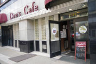 A sign requiring a COVID-19 protective mask is required to enter is in front of Dee's Cafe, Friday, May 14, 2021, in Pittsburgh's South Side neighborhood. (AP Photo/Keith Srakocic)