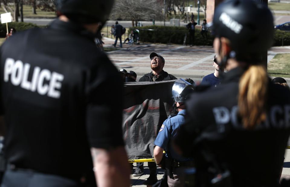 Anti-Trump protesters chant as police separate them from supporters of President Donald Trump gathered nearby during a March 4 Trump rally on the state Capitol steps in Denver, Saturday, March 4, 2017. (AP Photo/Brennan Linsley)
