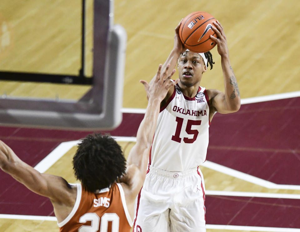 Oklahoma guard Alondes Williams (15) shoots the ball over Texas forward Jericho Sims (20) during the second half of an NCAA college basketball game in Norman, Okla., Thursday, March 4, 2021. (AP Photo/Kyle Phillips)