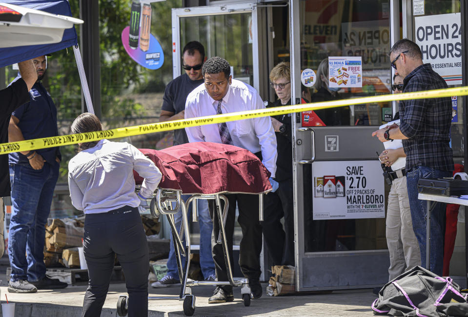 Las autoridades retiran el cadáver de un empleado de una tienda de la cadena 7-Eleven que murió baleado durante un asalto, el lunes 11 de julio de 2022, en Brea, California. (Mindy Schauer/The Orange County Register vía AP)