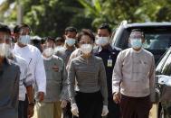 Myanmar leader Aung San Suu Kyi, center, wearing a protective face mask and shield walks to greet supporters as she leaves after a demonstration of the voting for the upcoming Nov. 8 general elections, Tuesday, Oct. 20, 2020, in Naypyitaw, Myanmar. (AP Photo/Aung Shine Oo)