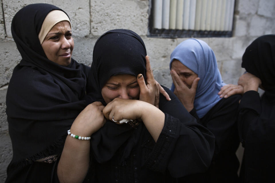 Relatives of Islamic Jihad militant, Abdullah Al-Belbesi, 26, who was killed in Israeli airstrikes, mourn his death in the family home, during his funeral in the town of Beit Lahiya, Northern Gaza Strip, Wednesday, Nov. 13, 2019. Gaza's Health Ministry said Wednesday that more Palestinians have been killed by ongoing Israeli airstrikes, bringing the death toll in the escalation over the past two days to at least 18. (AP Photo/Khalil Hamra)
