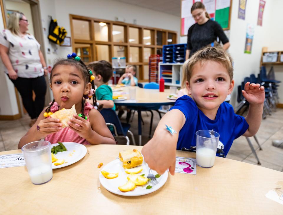 A child shows off a sticker on his wrist during lunch Aug. 21 at Encompass Early Education & Care Inc. in Allouez.