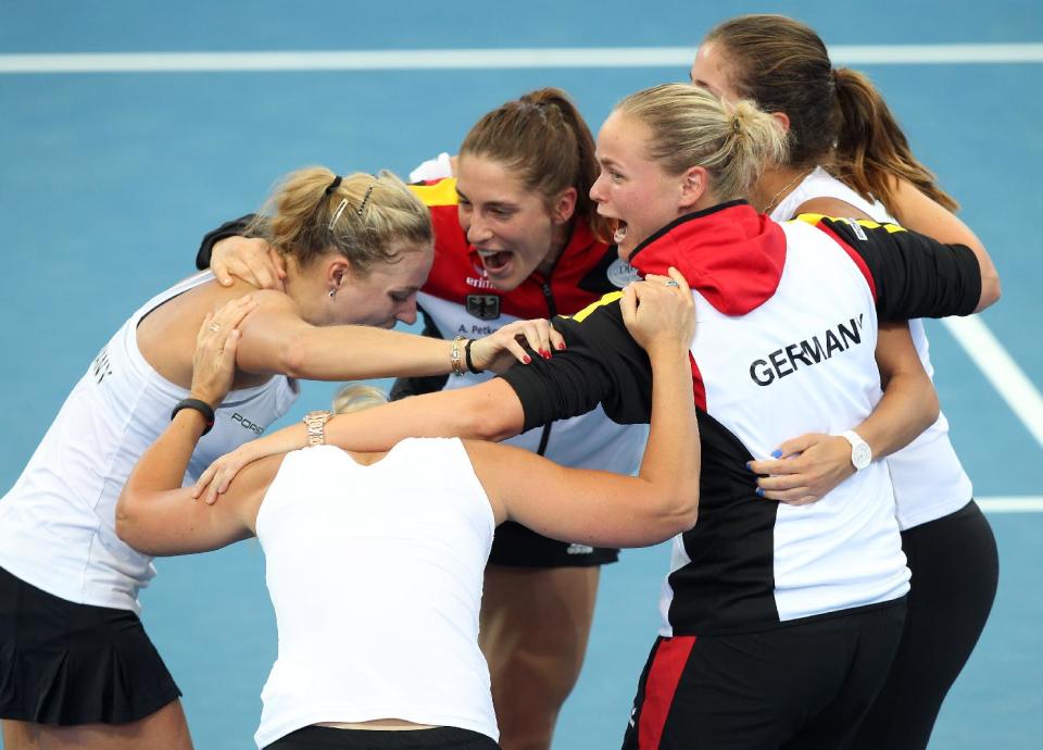 German team members Andrea Petkovic, Julia Georges, Anna-Lena Groenfeld, team captain Barbara Rittner and Angelique Kerber celebrate after defeating Australia 3-0 during their Fed Cup semifinals in Brisbane, Australia, Sunday, April 20, 2014. (AP Photo/Tertius Pickard)