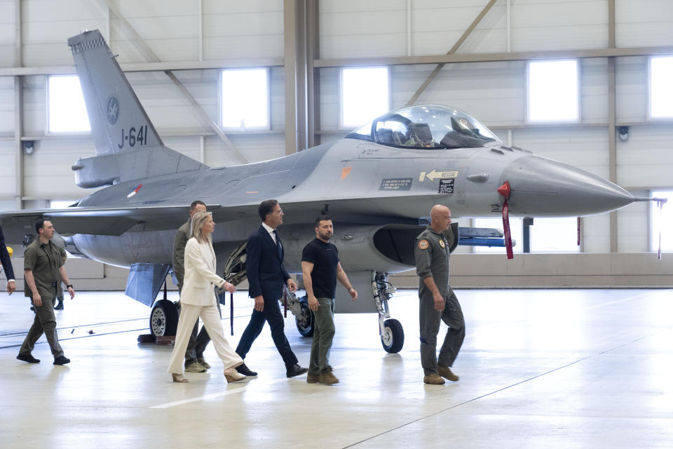 Ukrainian President Volodymyr Zelenskyy, second right, and Dutch caretaker Prime Minister Mark Rutte, center, look at F-16 fighter jets in Eindhoven, Netherlands, Sunday, Aug. 20, 2023. The leaders met at a military air base in the southern Dutch city, a day after Zelenskyy visited Sweden on his first foreign trip since attending a NATO summit in Lithuania last month. On Friday, the Netherlands and Denmark said that the United States had given its approval for the countries to deliver F-16s to Ukraine. (AP Photo/Peter Dejong)