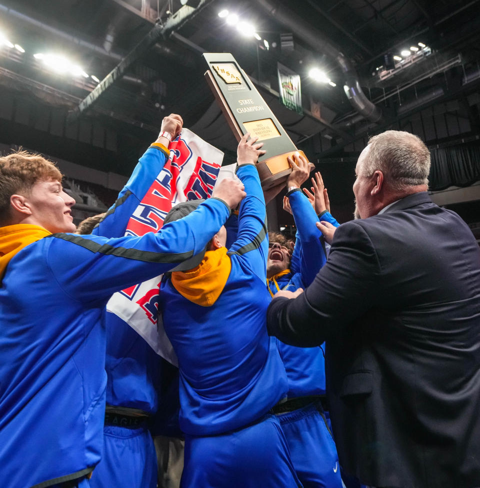 The Don Bosco wrestling team receives its Class 1A team championship trophy at Wells Fargo Arena on Saturday.