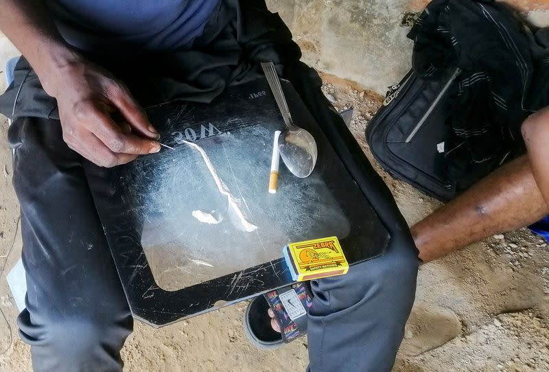 Man shows a substance known as "bombe", a mix of catalytic converters' crushed honeycomb and pills, in Kinshasa