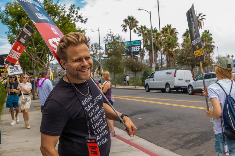 LOS ANGELES, CALIFORNIA - AUGUST 09: Actor Adam Conover with members and supporters of SAG-AFTRA and WGA picket in front of Paramount Pictures studios on August 09, 2023 in Los Angeles, California. Members of SAG-AFTRA and WGA (Writers Guild of America) have both walked out in their first joint strike against the studios since 1960. The strike has shut down a majority of Hollywood productions with today marking day 100 of the WGA strike against the Hollywood studios. (Photo by Momodu Mansaray/Getty Images)