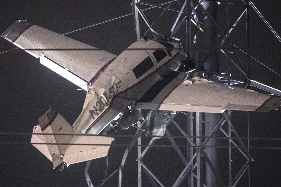 A small plane rests on live power lines after crashing, Sunday, Nov. 27, 2022, in Montgomery Village, a northern suburb of Gaithersburg, Md. (AP Photo/Tom Brenner)