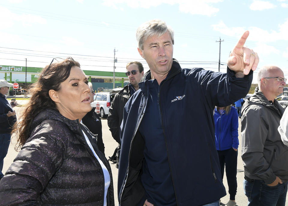 Nova Scotia Premier Tim Houston speaks with homeowner Karen Eckert, of Glace Bay, about the damage to her home in Glace Bay, Nova Scotia, Sunday, Sept. 25, 2022. A day after post-tropical storm Fiona left a trail of destruction through Atlantic Canada and eastern Quebec, residents of a coastal town in western Newfoundland continued to pick through wreckage strewn across their community, easily the most damaged area in the region. (Vaughan Merchant/The Canadian Press via AP)