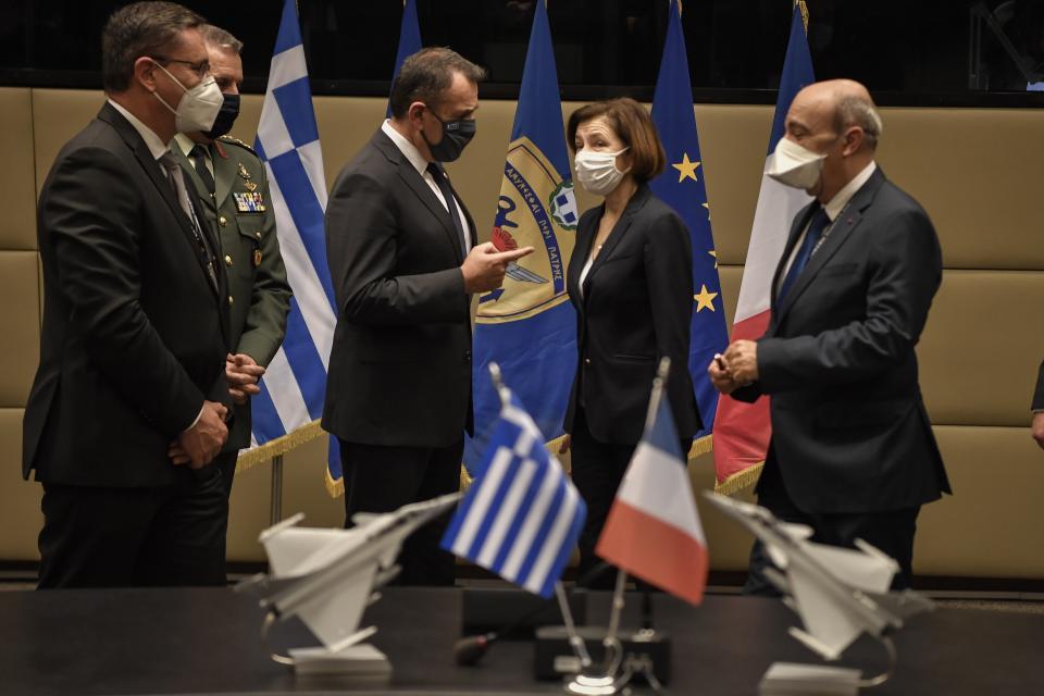 French Defense Minister Florence Parly, second left, and his Greek counterpart Nikos Panagiotopoulos, third right, speak after signing Rafale warplane deal in Athens, Monday, Jan. 25, 2021. Greece is due to sign a 2.3 billion euro ($2.8 billion) deal with France Monday to purchase 18 Rafale fighter jets to address tension with neighbor Turkey. (Louisa Gouliamaki/Pool via AP)