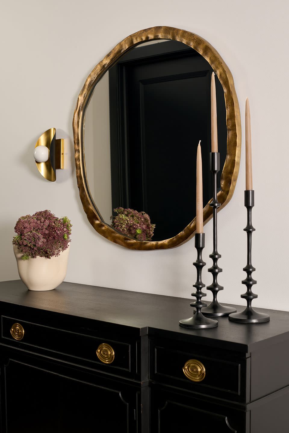 entryway credenze with an oval gold mirror on top