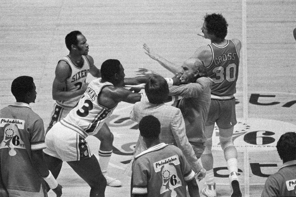 FILE - In this May 26, 1977, file photo, Philadelphia 76ers' Darrell Dawkins shoves Portland Trail Blazers coach Jack Ramsay after Ramsay tried to break up a fight on the floor between Dawkins and several other Blazers during the NBA basketball playoffs in Philadelphia. Ramsay, a Hall of Fame coach who led the Portland Trail Blazers to the 1977 NBA championship before he became one of the league's most respected broadcasters, has died following a long battle with cancer. He was 89. (AP Photo/Gene Puskar, File)