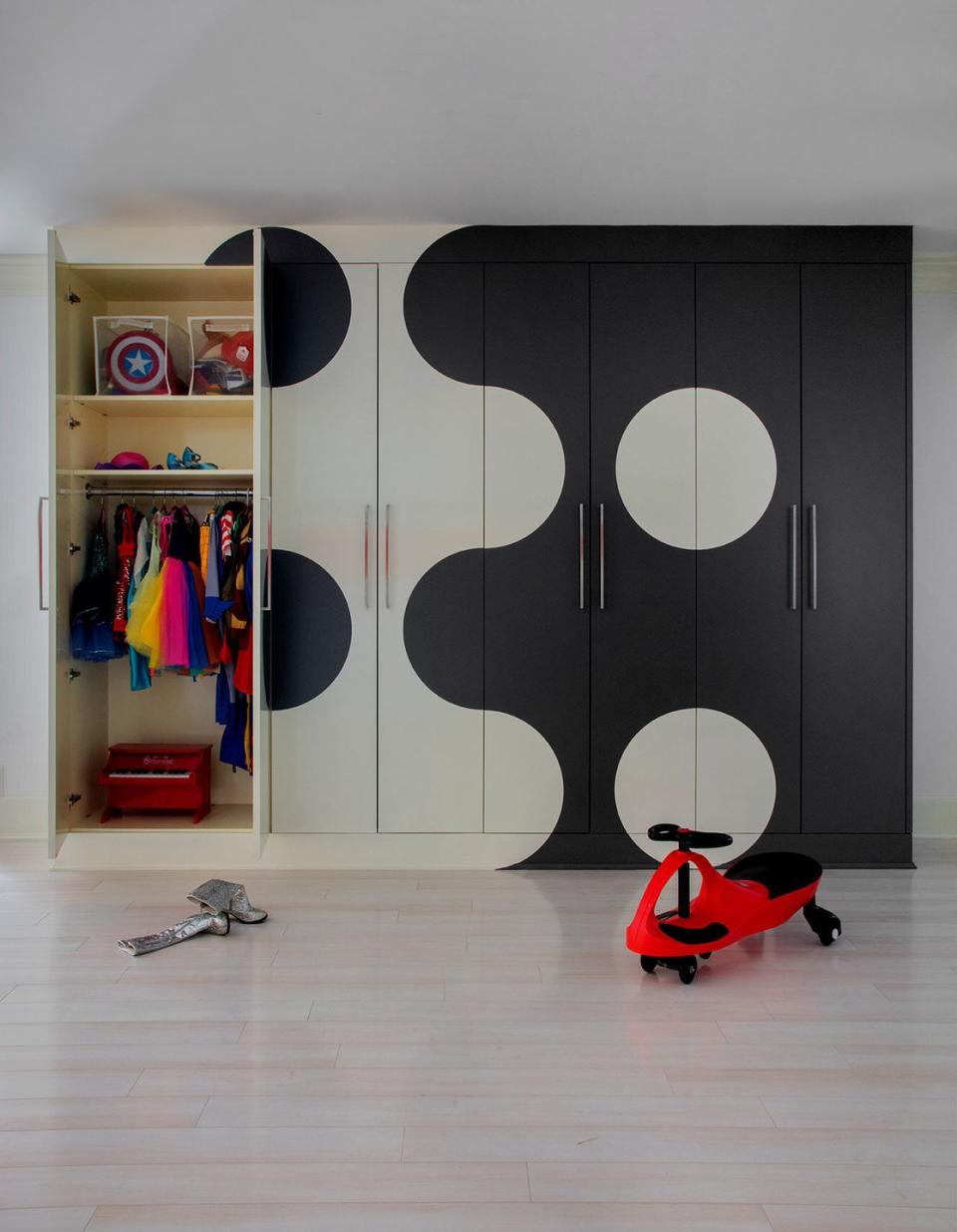 a closet with a black door and a red toy figure in front of it