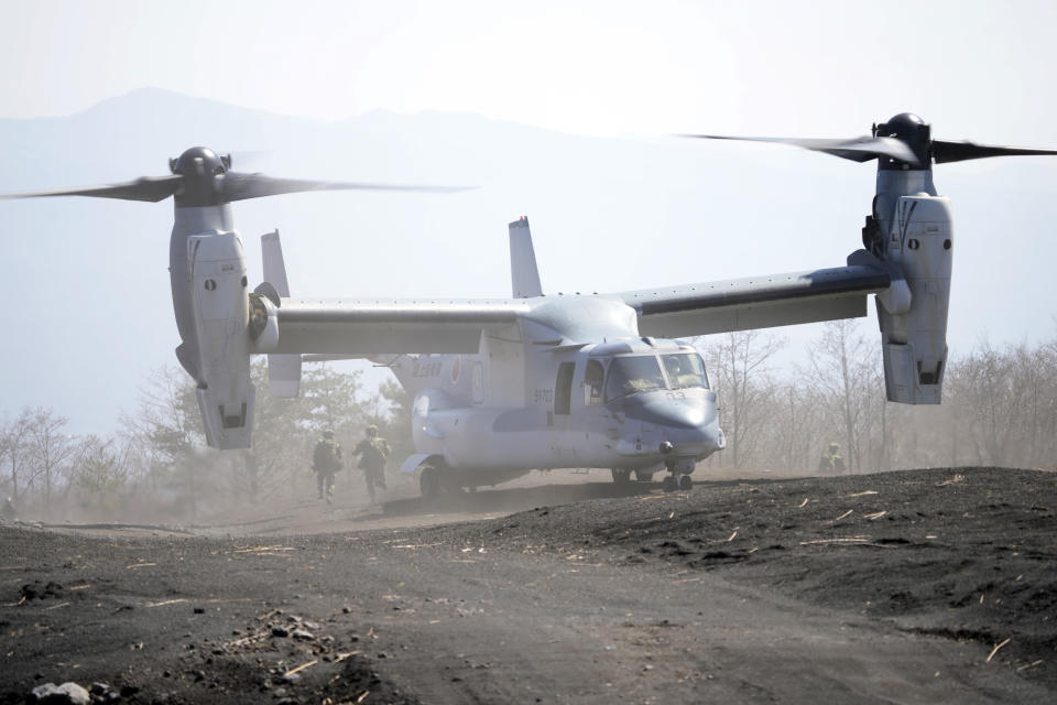 Members of the Japan Ground Self-Defense Force (JGSDF) rush out from a V-22 osprey as they take part in a joint military helicopter borne operation drill between Japan Ground Self-Defense Force (JGSDF) and U.S. Marines at the Higashi Fuji range in Gotemba, southwest of Tokyo, Tuesday, March 15, 2022. (AP Photo/Eugene Hoshiko)