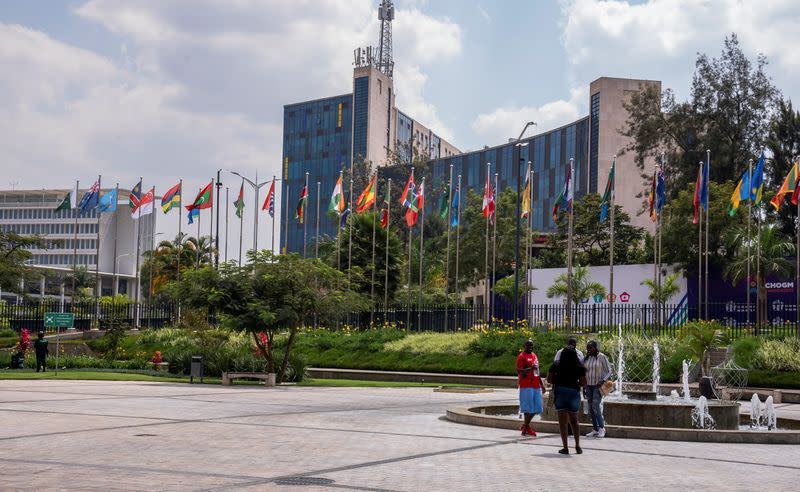 Delegates pose for a photograph near flags representing Commonwealth countries outside the Kigali Convention Centre, the venue hosting the Commonwealth Heads of Government Meeting in Kigali