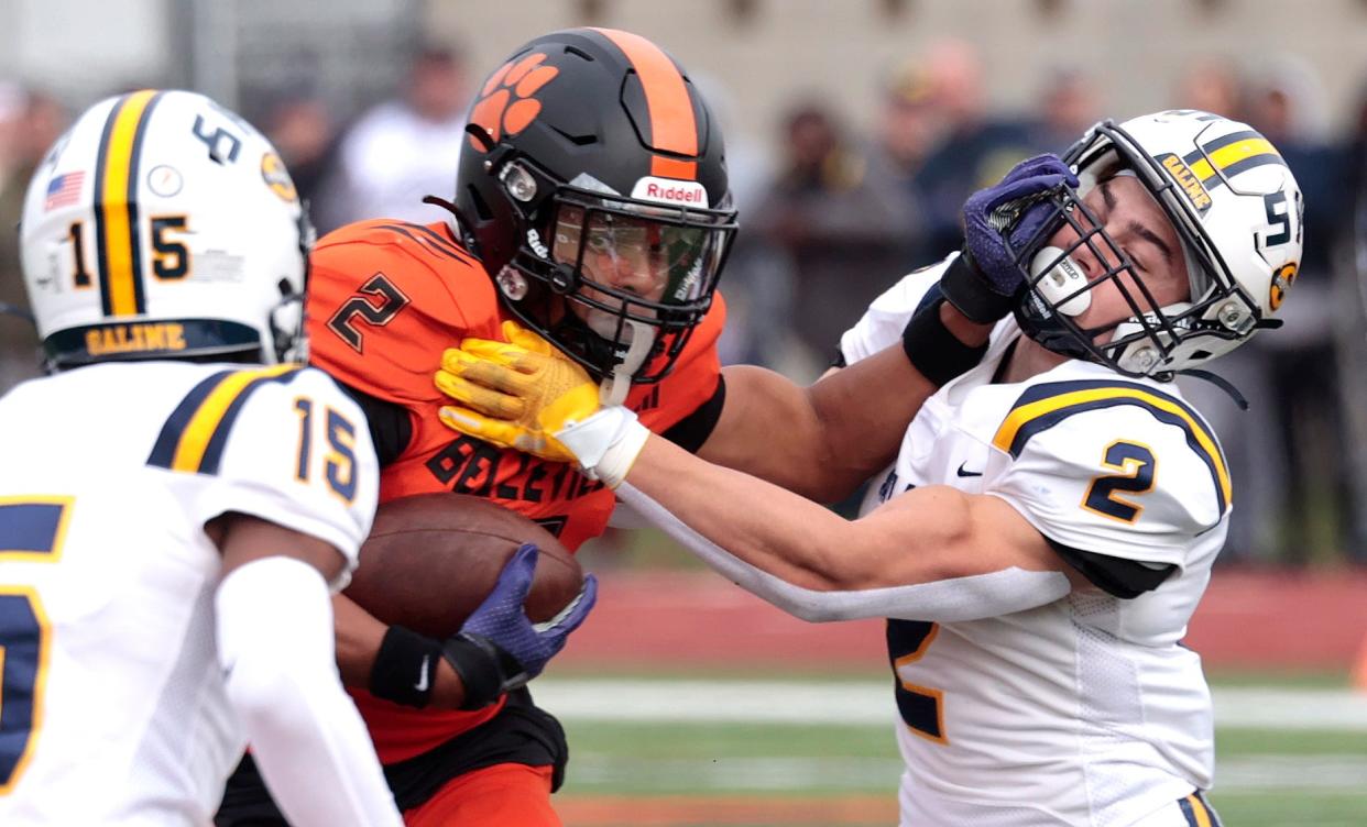 Belleville's Adrian Walker stiff arms Saline's Ryan Kavanaugh (2) as he runs for extra yardage during first-half action in the MHSAA Division 1 playoff game between Saline and Belleville at Belleville High School on Saturday, Nov. 4, 2023.