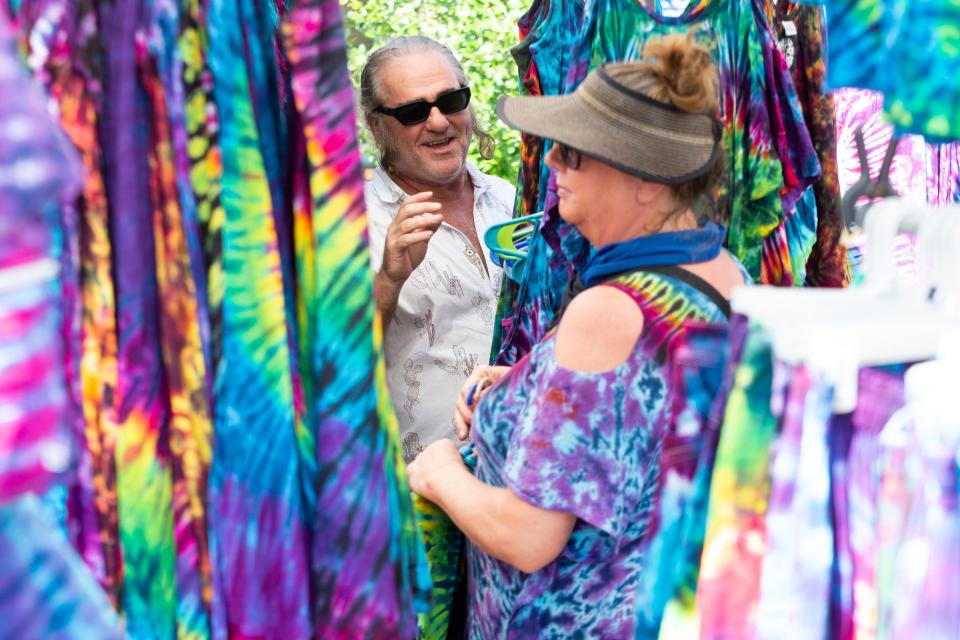 Russell and Lauren Autin talk about their tie-dye wares with a customer in their 2 Dye 4 booth during the Cooper-Young Festival in Midtown Memphis, on Saturday, September 16, 2023.