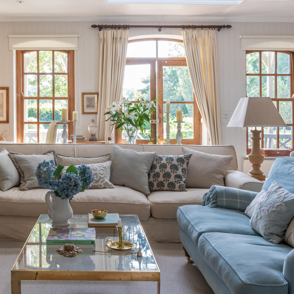 Living room with neutral and blue sofas and French wooden doors to the garden