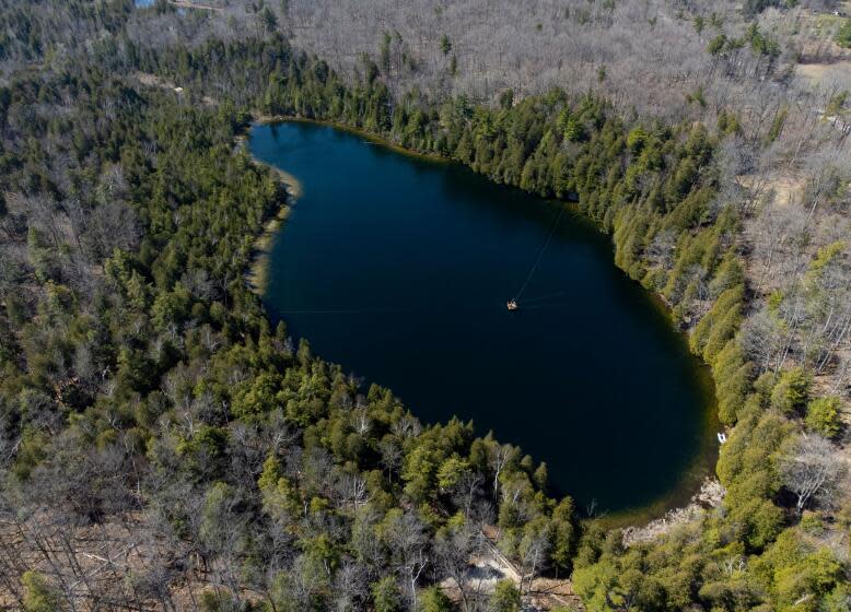An aerial view of Crawford Lake as a team consisting of scientists from Carleton University and Brock University gather sediment layer samples from the lake bottom at the Crawford Lake Conservation Area near Milton, Ontario, Canada, April 12, 2023. The view under the surface of Crawford Lake tells a different story. Scientists believe the lake's exceptionally well-preserved sediment layers serve as a reference point for a proposed new geological chapter in the planet's history, defined by the considerable changes wrought by human activity: the Anthropocene. The International Commission on Stratigraphy's Anthropocene Working Group on July 11, 2023, named the lake as the embodiment of the proposed Anthropocene epoch. (Photo by Peter POWER / AFP) (Photo by PETER POWER/AFP via Getty Images)