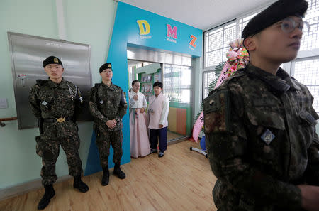 Graduates of elementary school wait to attend at a graduation ceremony near South Korean soldiers at Taesungdong freedom village inside the demilitarized zone between North and South Korea, near the border village of Panmunjom in Paju, South Korea, Friday, Jan. 11, 2019. Lee Jin-man/Pool via REUTERS