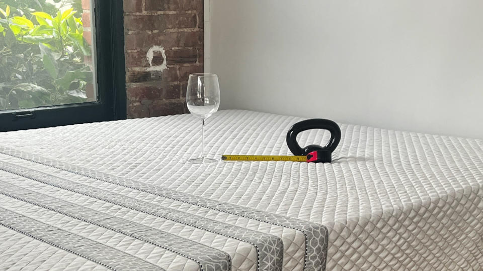 A wine glass, kettlebell and tape measure on the Leesa Sapira Hybrid Mattress