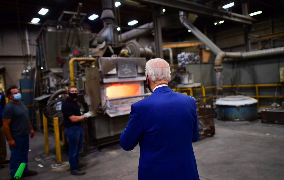 Democratic U.S. presidential nominee and former Vice President Joe Biden walks towards two workers waiting at an aluminum forge as he tours Wisconsin Aluminum Foundry before delivering remarks at a campaign event in the factory in Manitowoc, Wisconsin, U.S., September 21, 2020.  REUTERS/Mark Makela