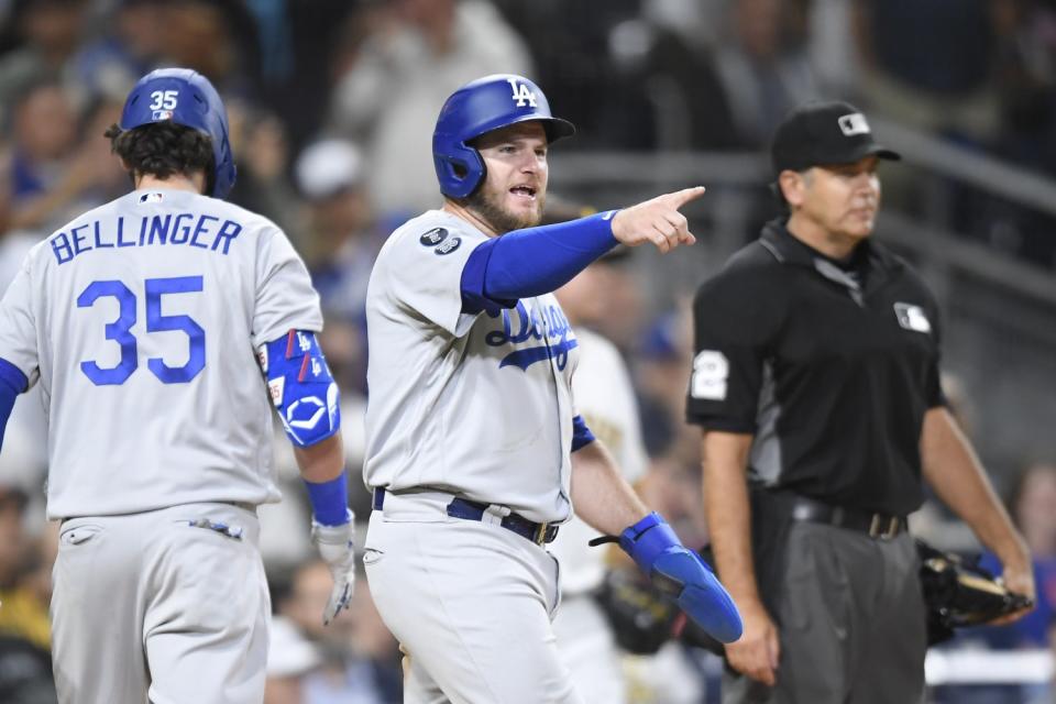 Dodgers' Max Muncy points out to Justin Turner after scoring.