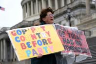 A demonstrator stands outside the US Capitol as White House lawyers began their defense of President Donald Trump at his Senate impeachment trial