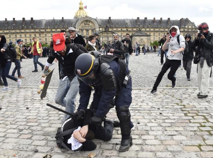 A police officer clashes with a demonstrator near the Invalides during a protest against proposed labour reforms, in Paris on June 14, 2016 (AFP Photo/Dominique Faget)