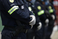 State police, wearing disposable gloves, guard the perimeter of Las Americas General Hospital in Ecatepec, a suburb of Mexico City, Wednesday, May 20, 2020. Mexico City, one of the world's largest cities and the epicenter of the country's coronavirus epidemic, will begin a gradual reopening June 1, its mayor said Wednesday, even as daily new infections continued to set records.(AP Photo/Rebecca Blackwell)