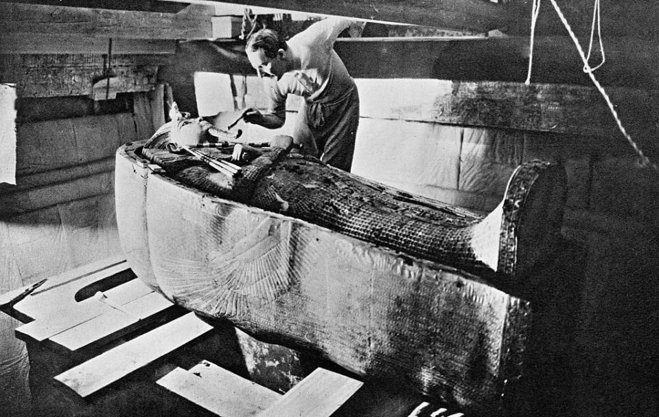 man brushes dust off king tut's sarcophagus